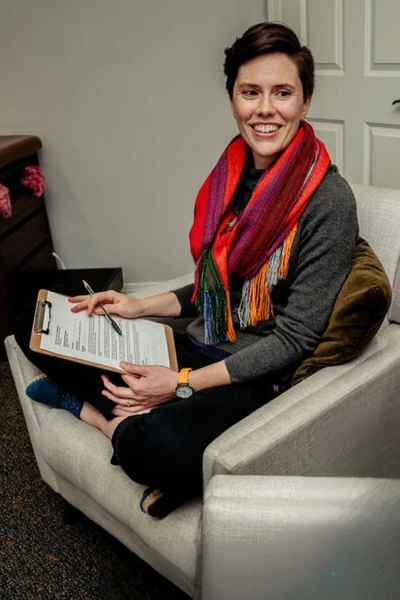 Midwife Caroline Sausler smiles at a person outside the photo who is visiting the Puget Sound office for preconception care