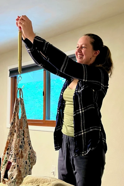 Midwife Britney Zell weighs a baby in a sling after a home birth